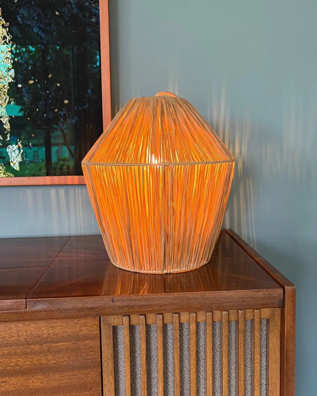 A glowing rattan table lamp on the radiogram