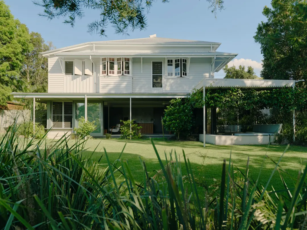 The back of the house across the lawn: the Queenslander up top and the level built in underneath