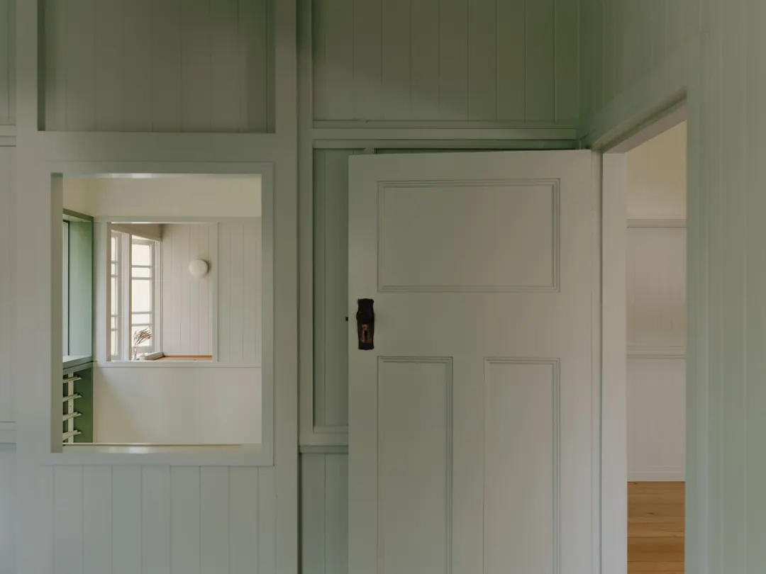 A VJ-lined hall with a panelled door and an internal window